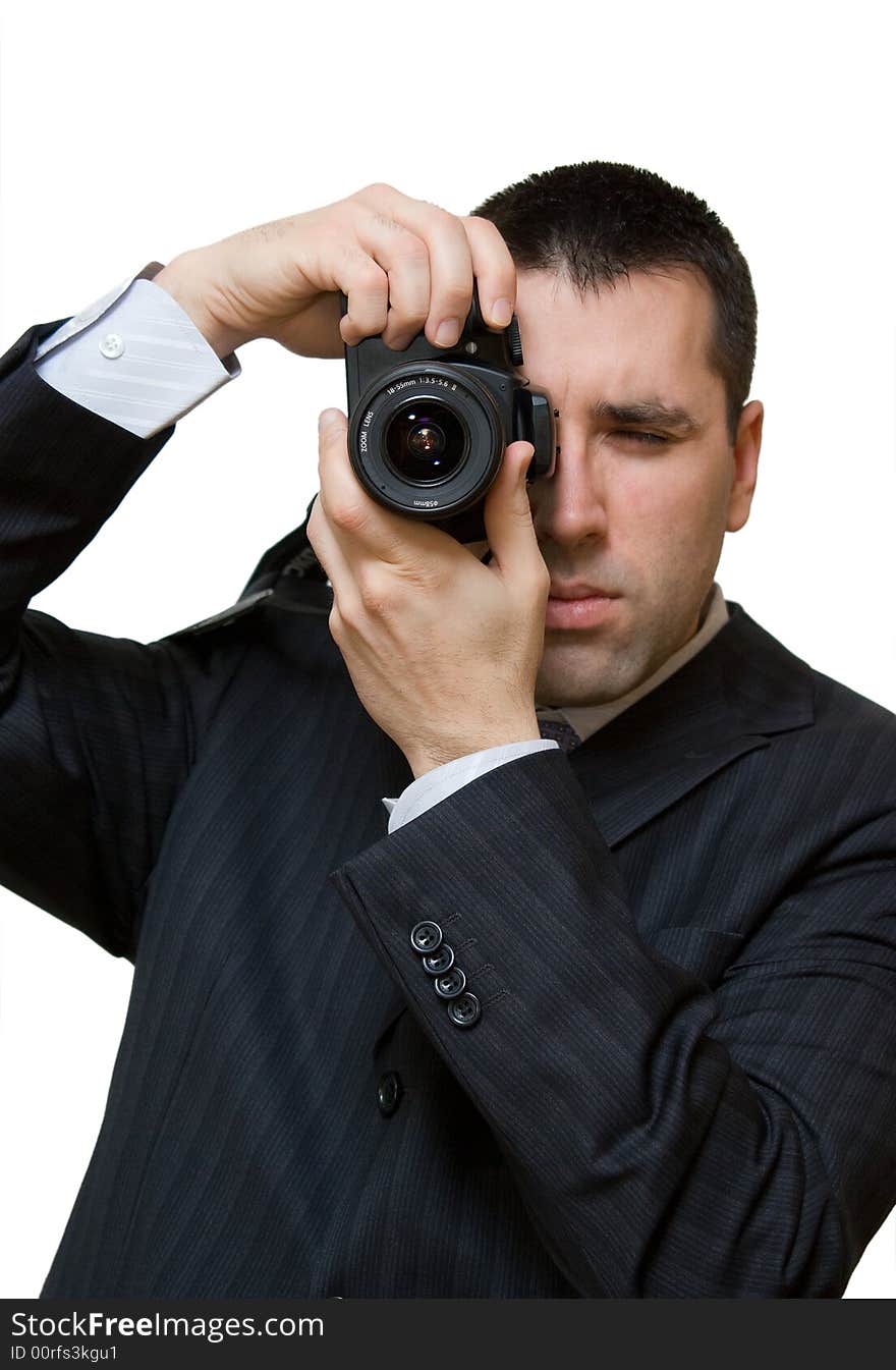 A man, wearing a suit, holding a camera vertically, taking a portrait shot. A man, wearing a suit, holding a camera vertically, taking a portrait shot