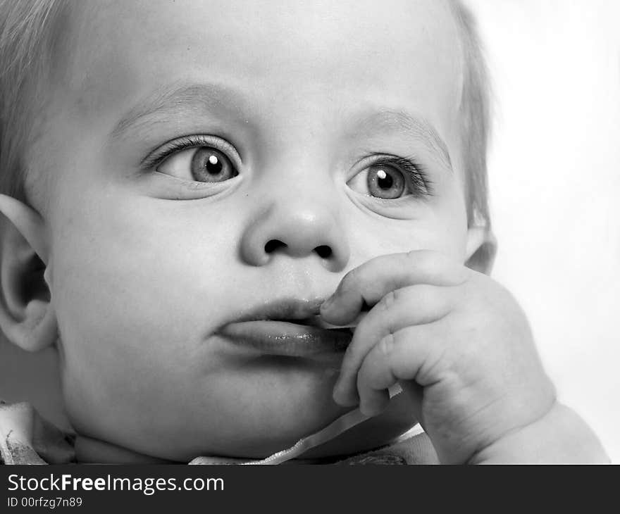 Baby looking sideways on grey background black-and-white