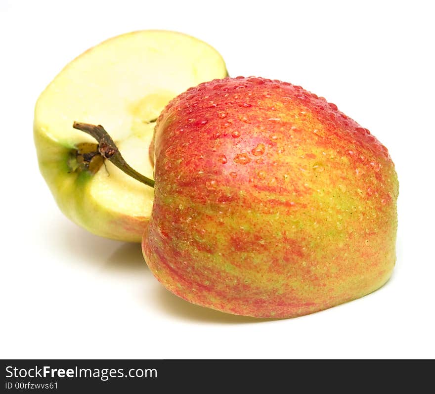 Two half one red apples covered by water drops. Isolation on white. Shallow DOF.