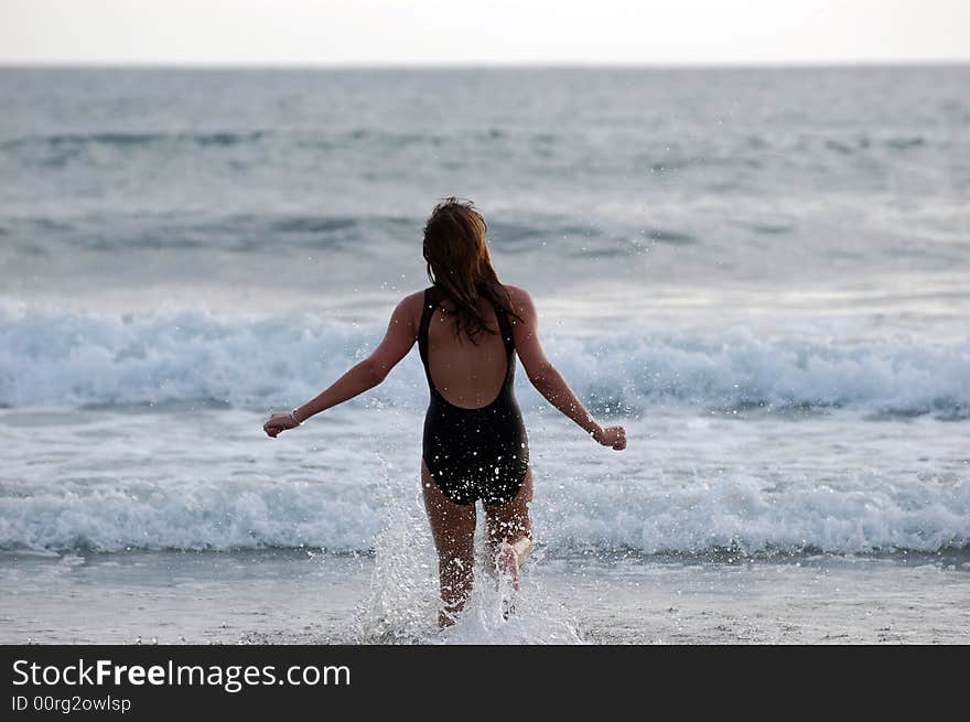 Teen model running into the waves. Teen model running into the waves.