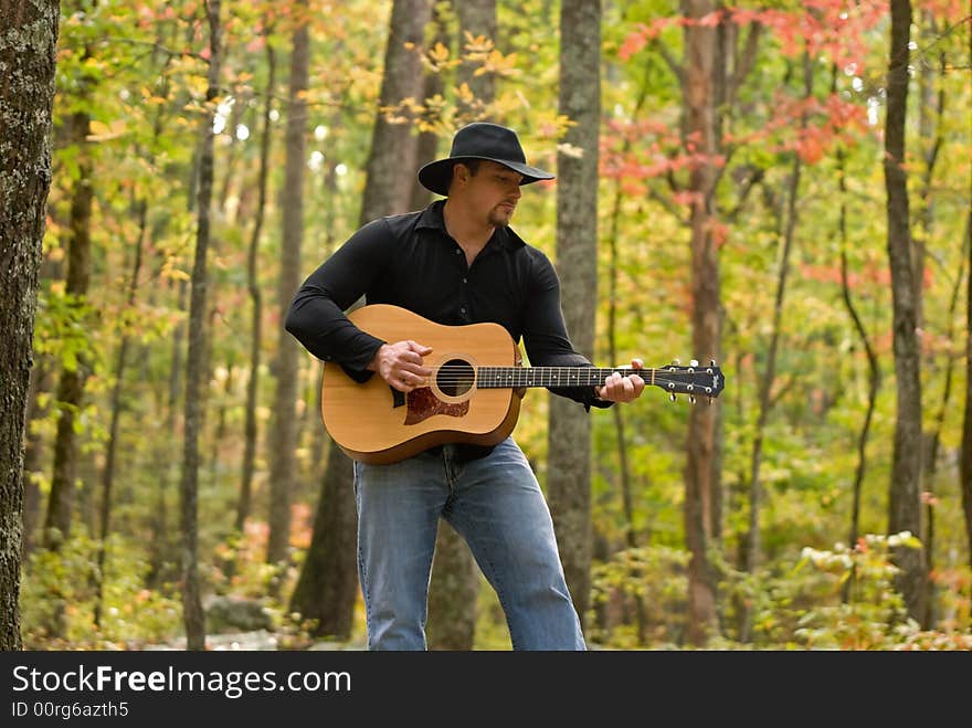 A shot of a young manpicking a guitar. A shot of a young manpicking a guitar.