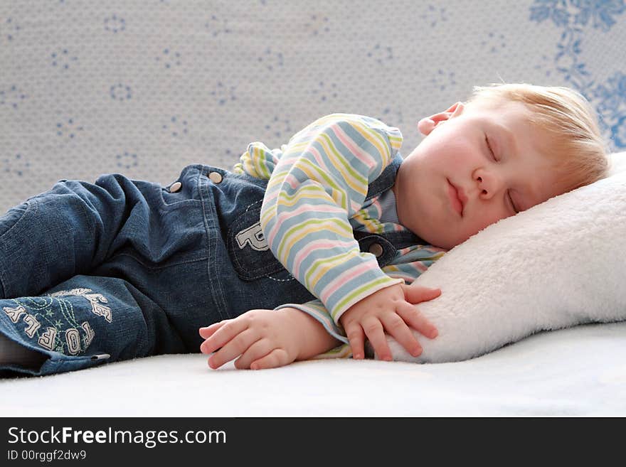 The small beautiful boy sleeps a head on a pillow. The small beautiful boy sleeps a head on a pillow