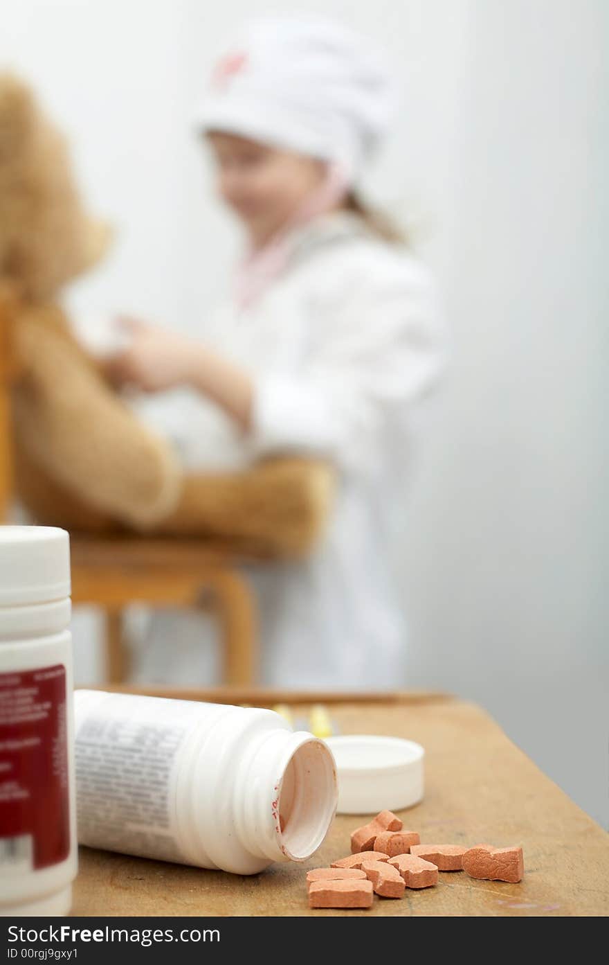 Pills close-up with a girl playing doctor foreground