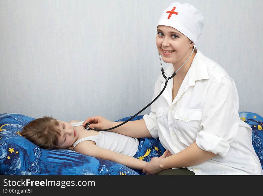 A doctor examines a girl with phonendoscope. A doctor examines a girl with phonendoscope