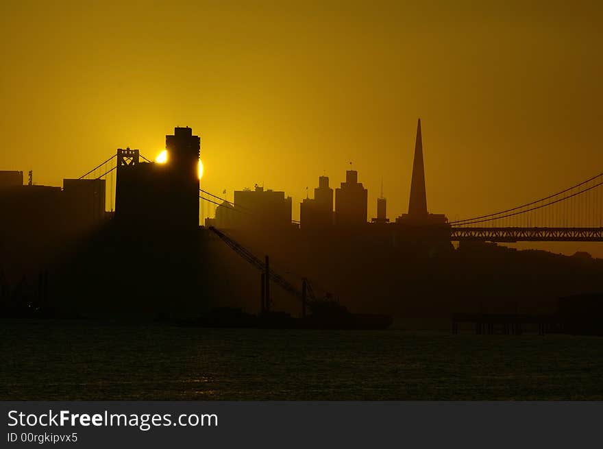 Sun sets in downtown San Francisco.  This photograph was taken from Oakland harbor. Sun sets in downtown San Francisco.  This photograph was taken from Oakland harbor.