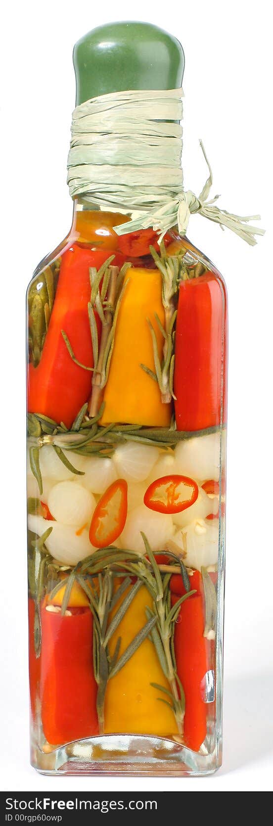 Marinated vegetables in glass bottle on white