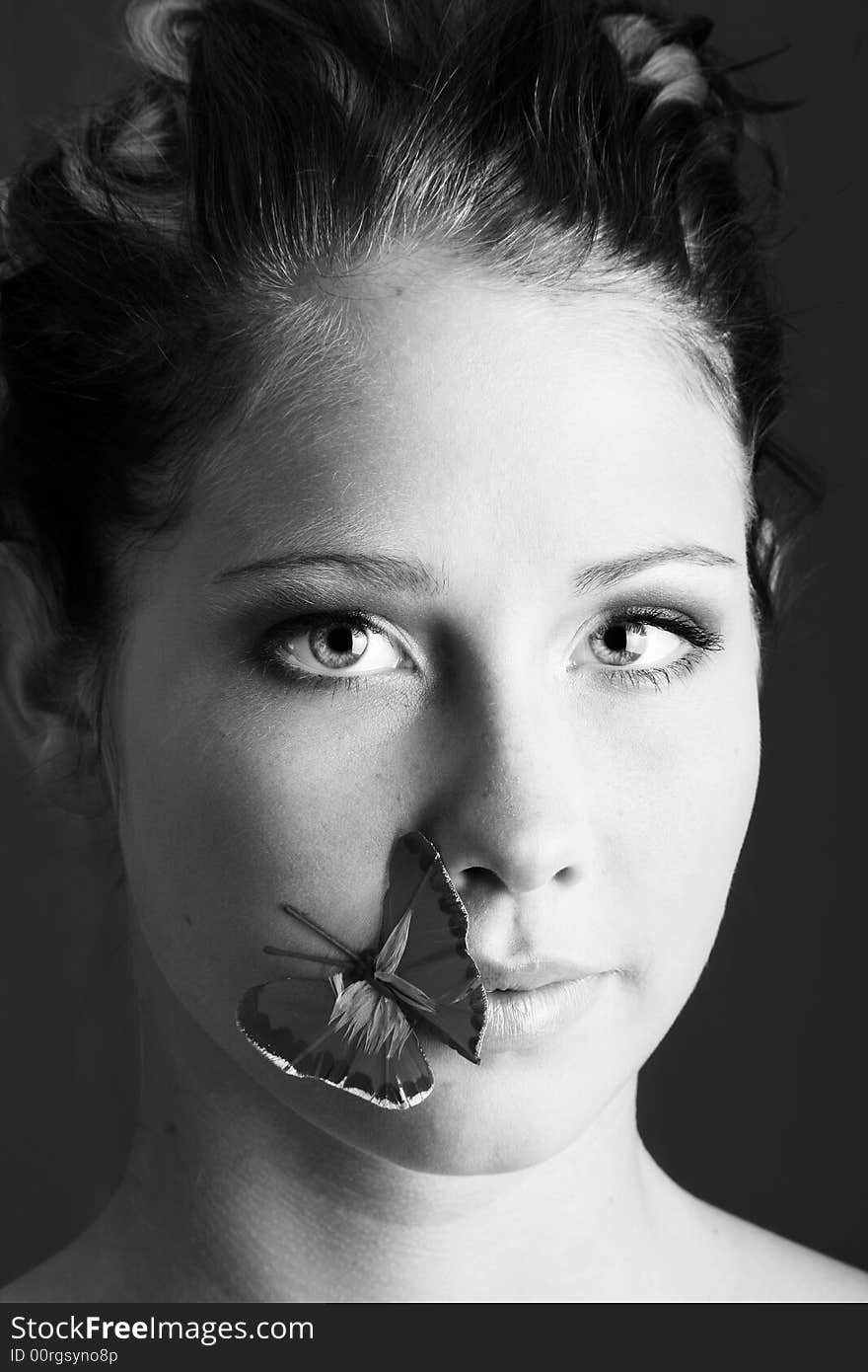 Beauty portrait of a beautiful young woman with a butterfly on her face. Beauty portrait of a beautiful young woman with a butterfly on her face