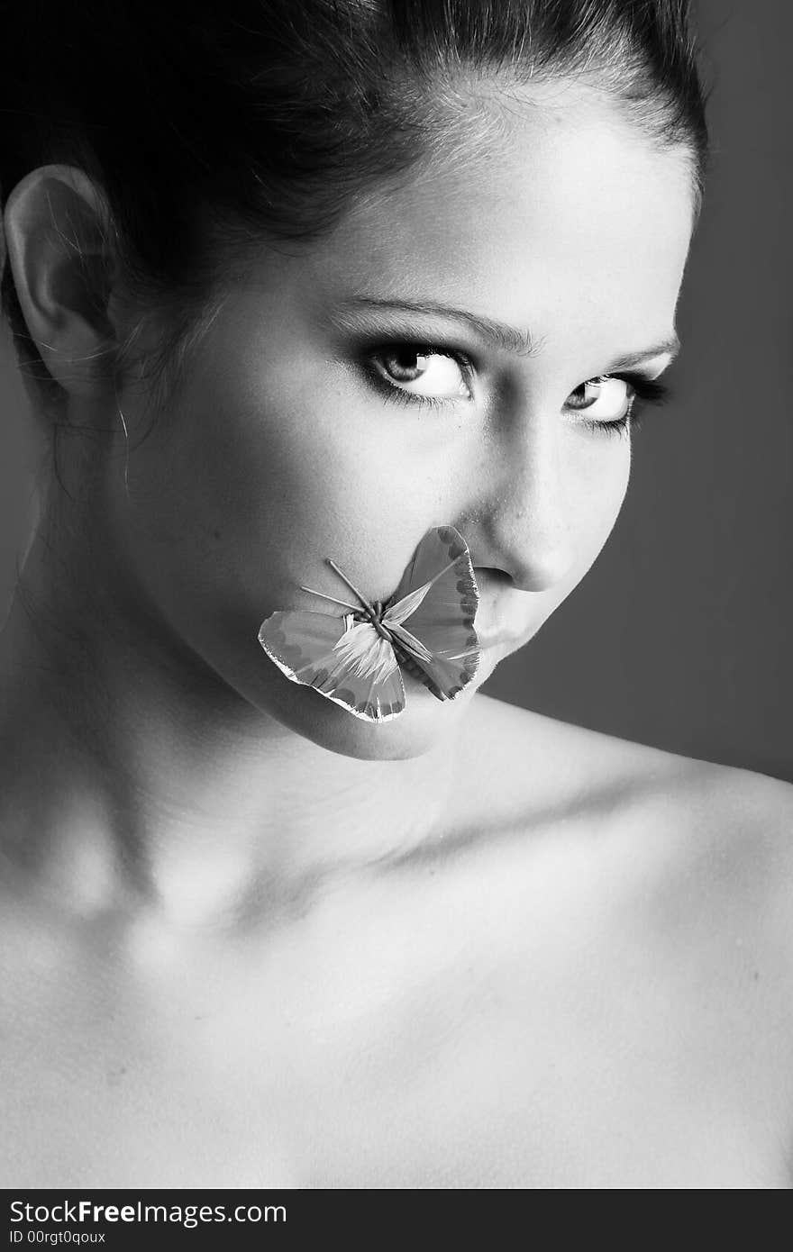 Beauty portrait of a beautiful young woman with a butterfly on her face. Beauty portrait of a beautiful young woman with a butterfly on her face