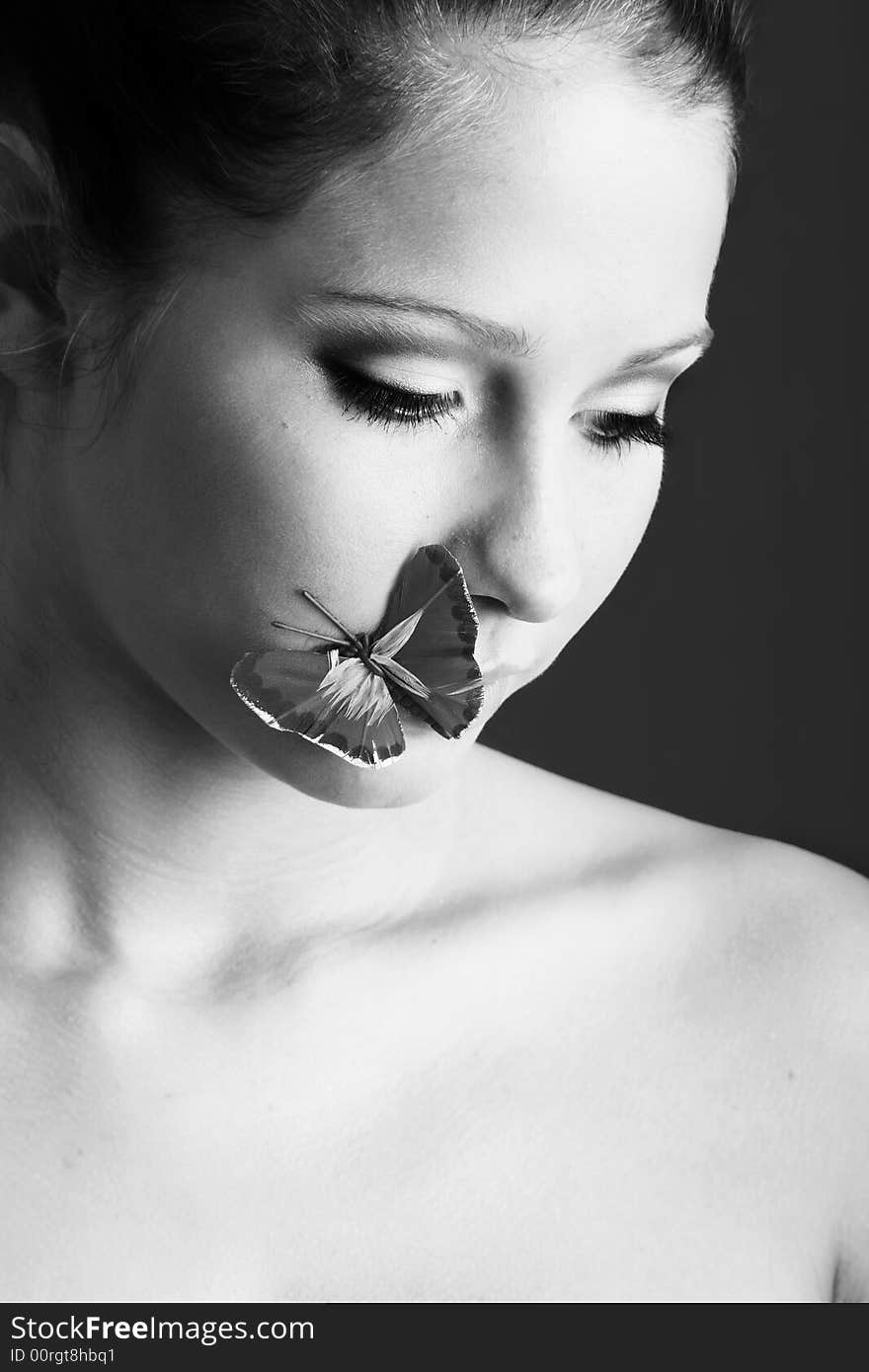 Beauty portrait of a beautiful young woman with a butterfly on her face. Beauty portrait of a beautiful young woman with a butterfly on her face