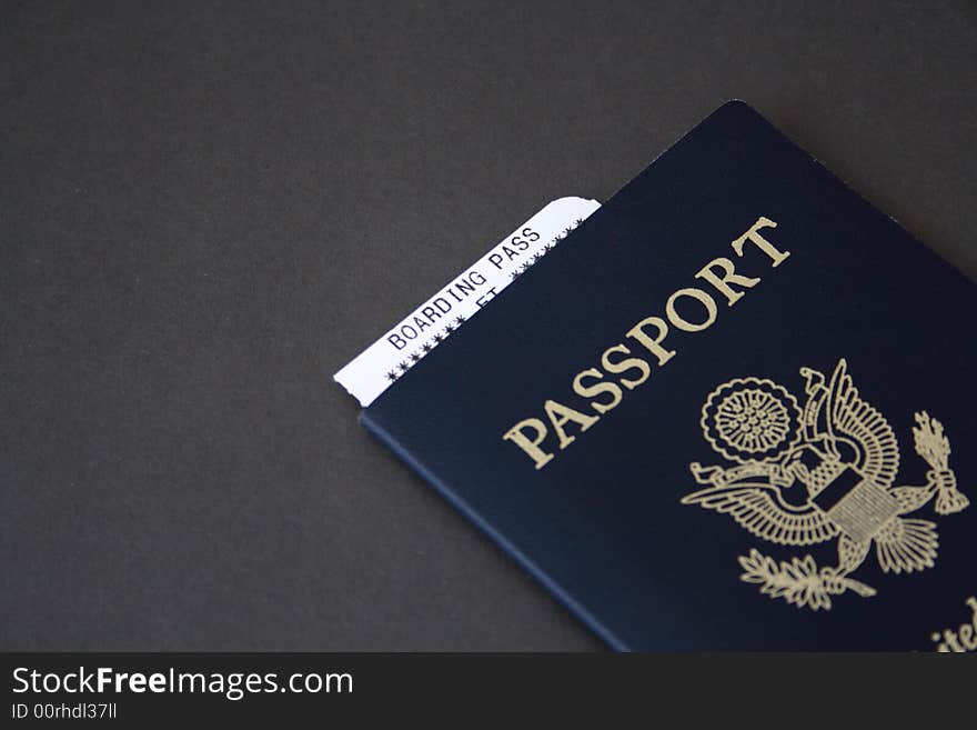 Passport with boarding pass on a dark gray background. Passport with boarding pass on a dark gray background