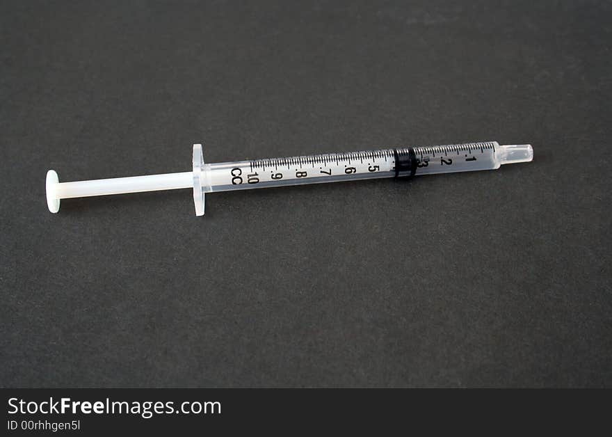 Hypodermic needle on a grey background