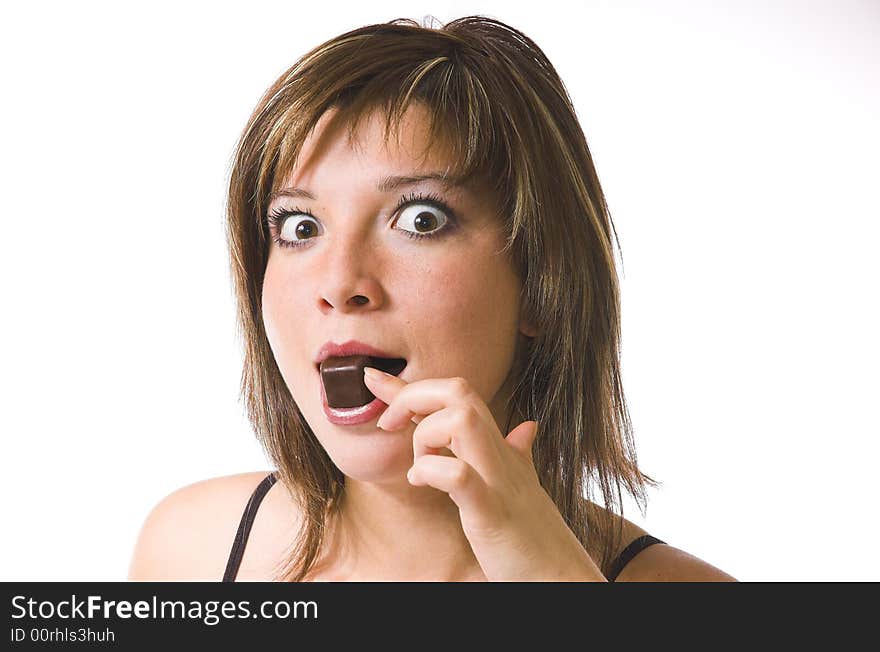 The beautiful girl eats a sweet on a white background