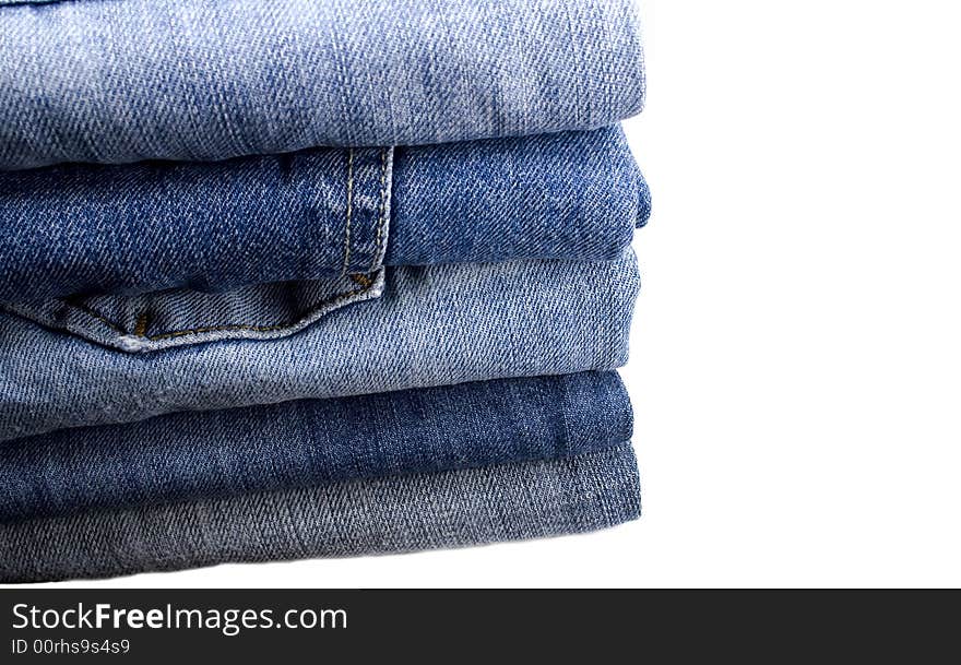 Stack of blue jeans over white