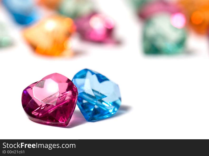 Magenta, blue and a group of colored glass hearts on white background