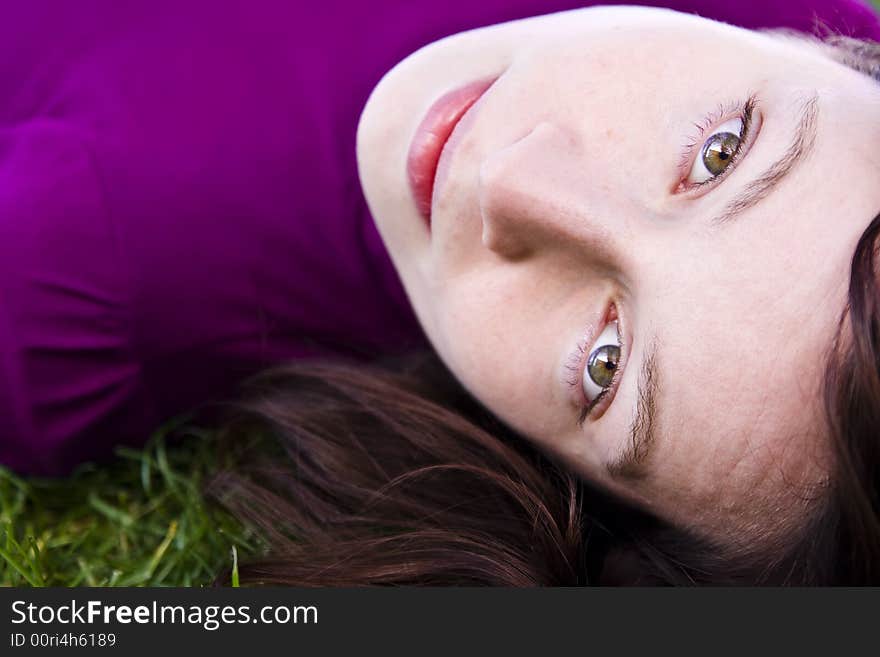 Green eyed beauty laying down in the grass