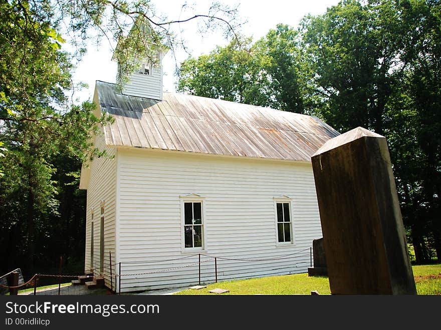 A white church chapel in a graveyard. A white church chapel in a graveyard.