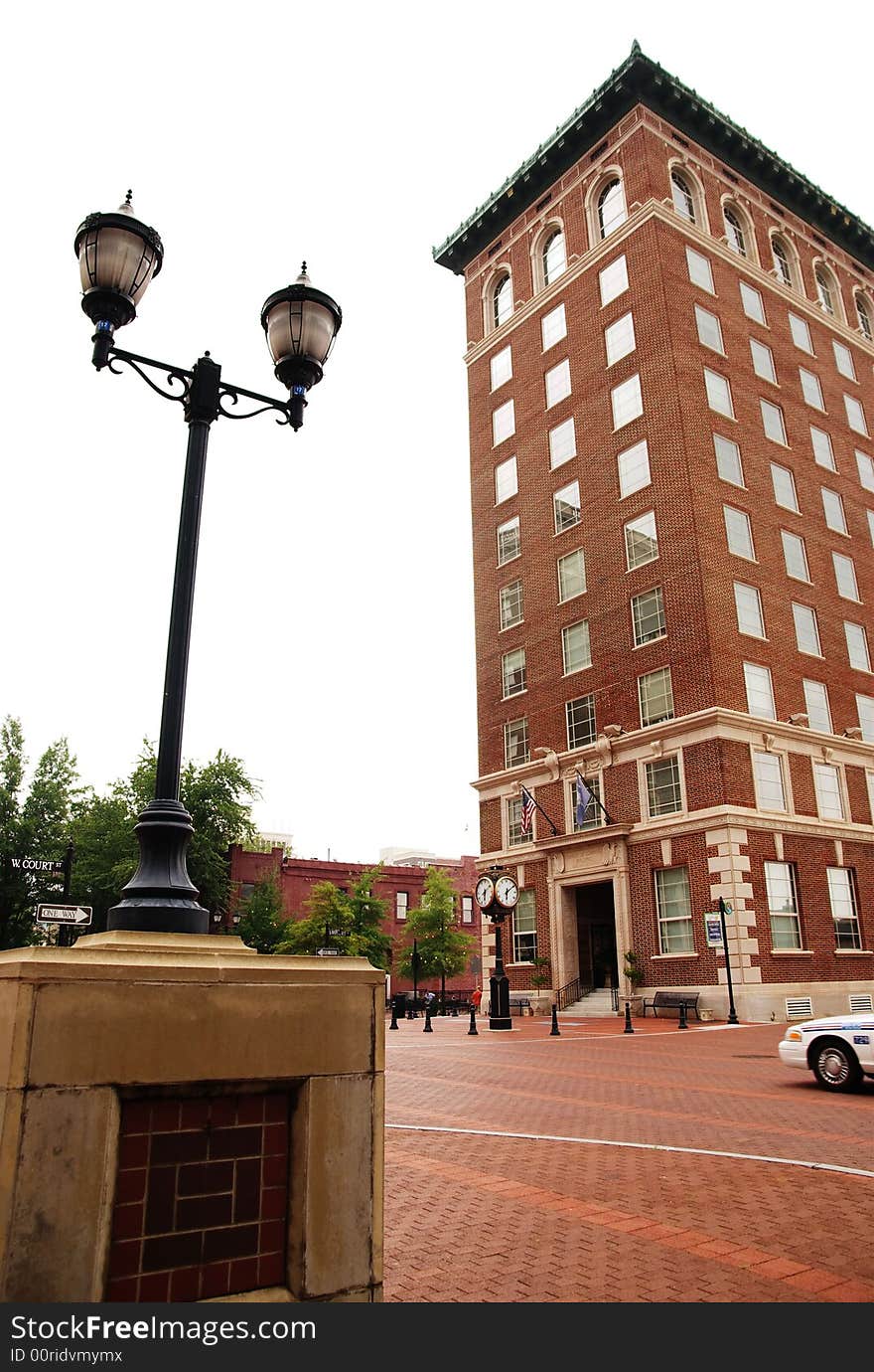 A tall building on a street side with lamp post. A tall building on a street side with lamp post.