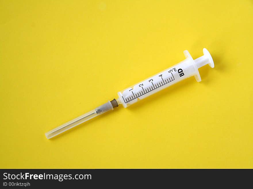 Syringe isolated on yellow background. Syringe isolated on yellow background.