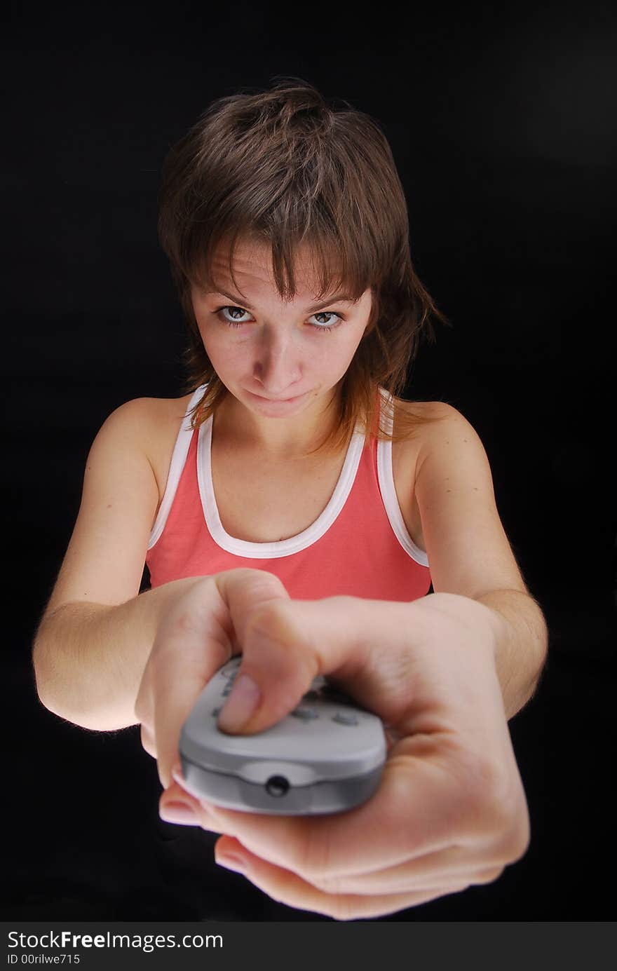 Young woman with tv remote control , isolated on black background. Young woman with tv remote control , isolated on black background