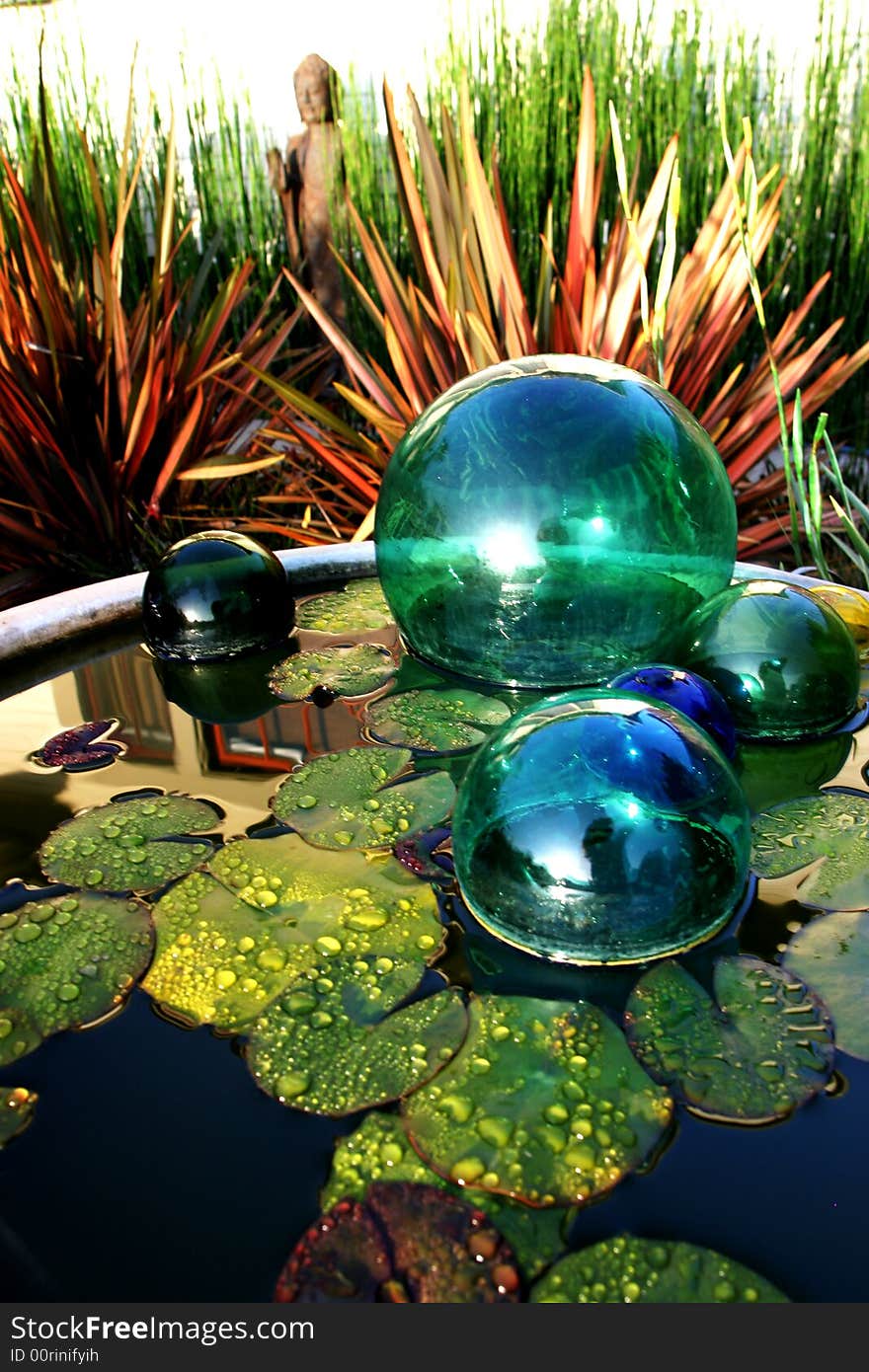 Japanese fishing weights in a birdbath with lily pads