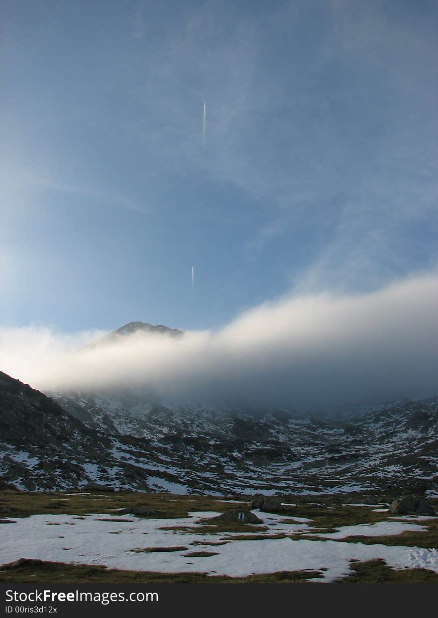 Vertical view of a cloudy mountain with 2 airplanes ascending. Vertical view of a cloudy mountain with 2 airplanes ascending