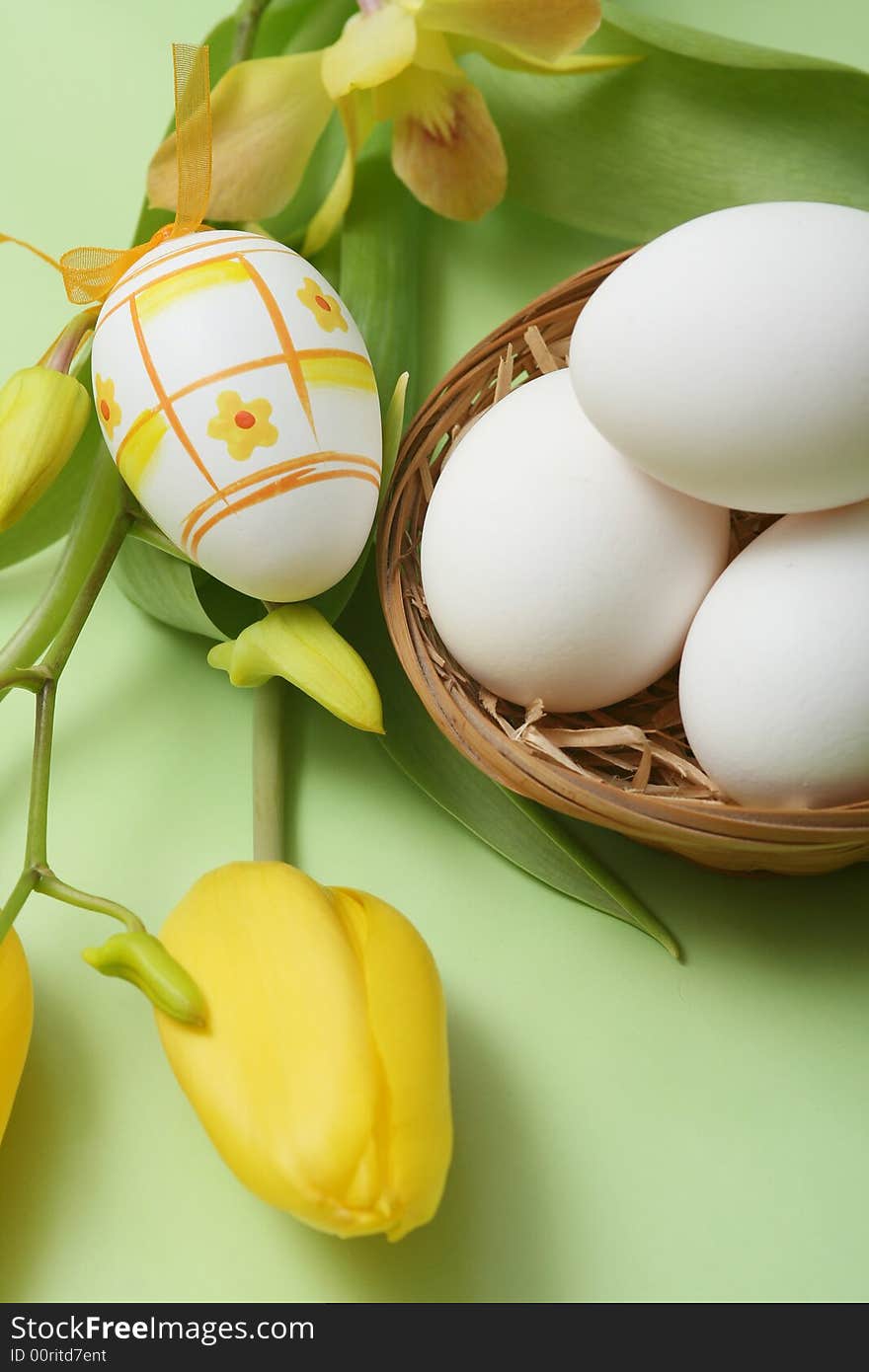 Easter egg with yellow tulip and orchid on green background. Easter egg with yellow tulip and orchid on green background.