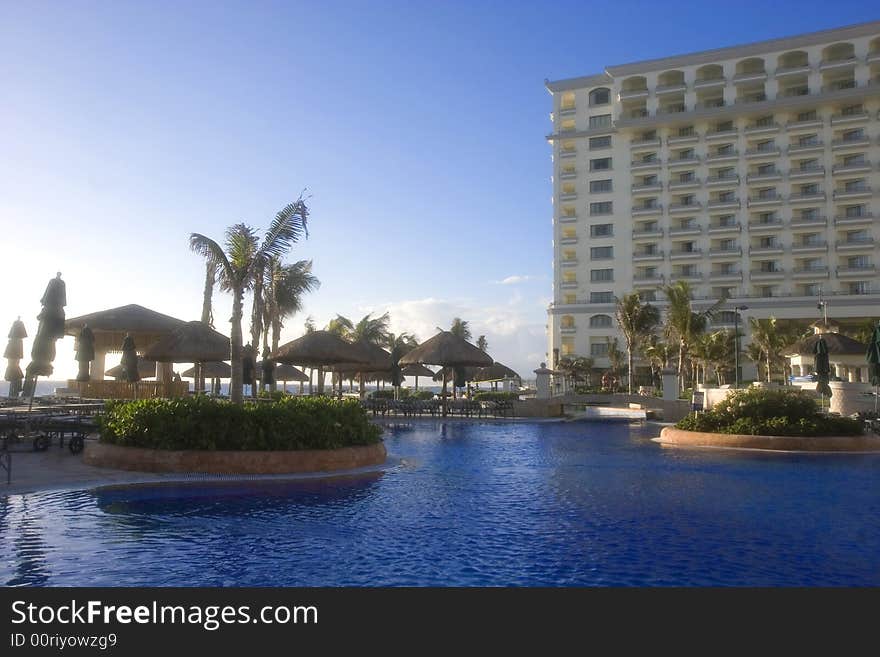 A large blue lagoon type pool at an oceanside resort hotel. A large blue lagoon type pool at an oceanside resort hotel