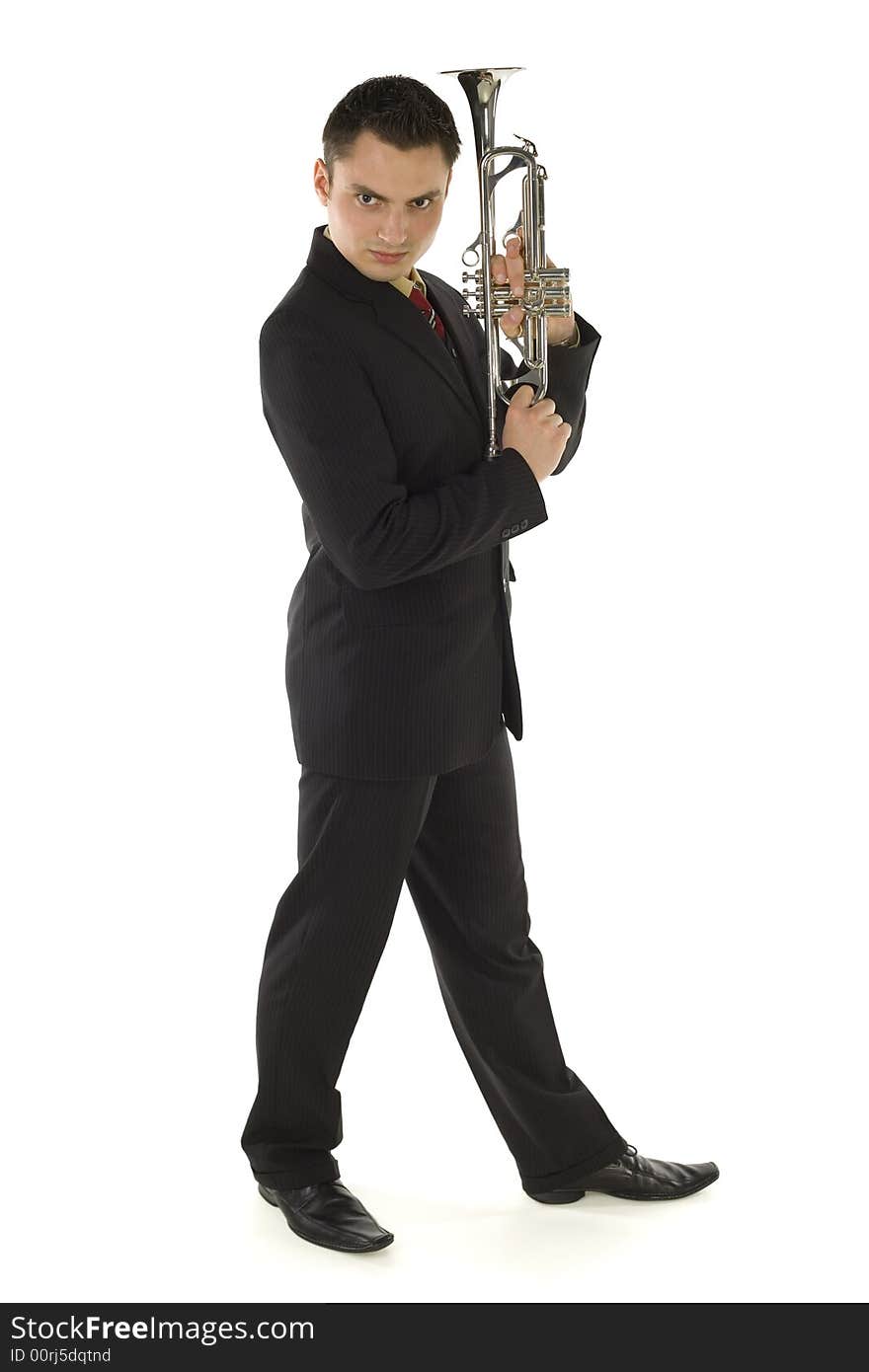 Man in suit holding a trumpet and posing. He's looking at camera. Whole body. Isolated on white background. Man in suit holding a trumpet and posing. He's looking at camera. Whole body. Isolated on white background.