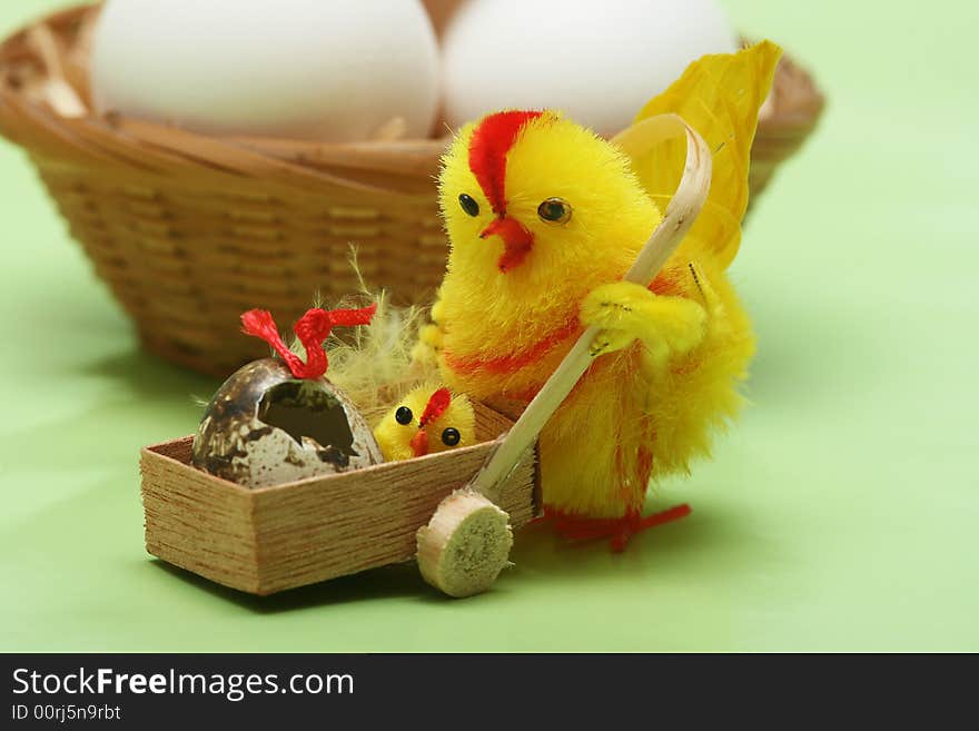 Easter motive.Hen and her chick,white eggs on green background.