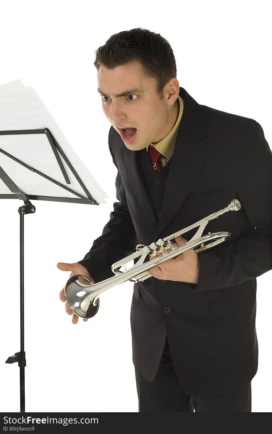 Astonished trumpeter standing in front of stillage. He's saw something on sheet music. White background. Astonished trumpeter standing in front of stillage. He's saw something on sheet music. White background.