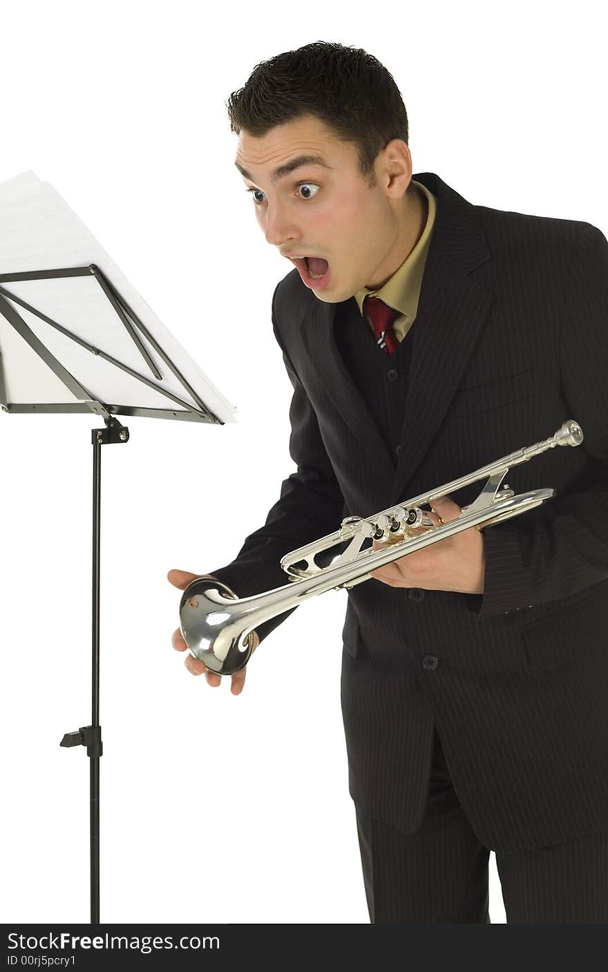 Astonished trumpeter standing in front of stillage. He's saw something on sheet music. White background. Astonished trumpeter standing in front of stillage. He's saw something on sheet music. White background.