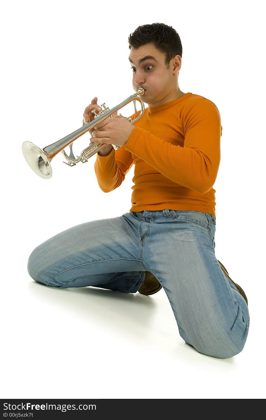 Man in orange blouse kneeling and trumpet. Low angle view. Isolated on white background. Man in orange blouse kneeling and trumpet. Low angle view. Isolated on white background.