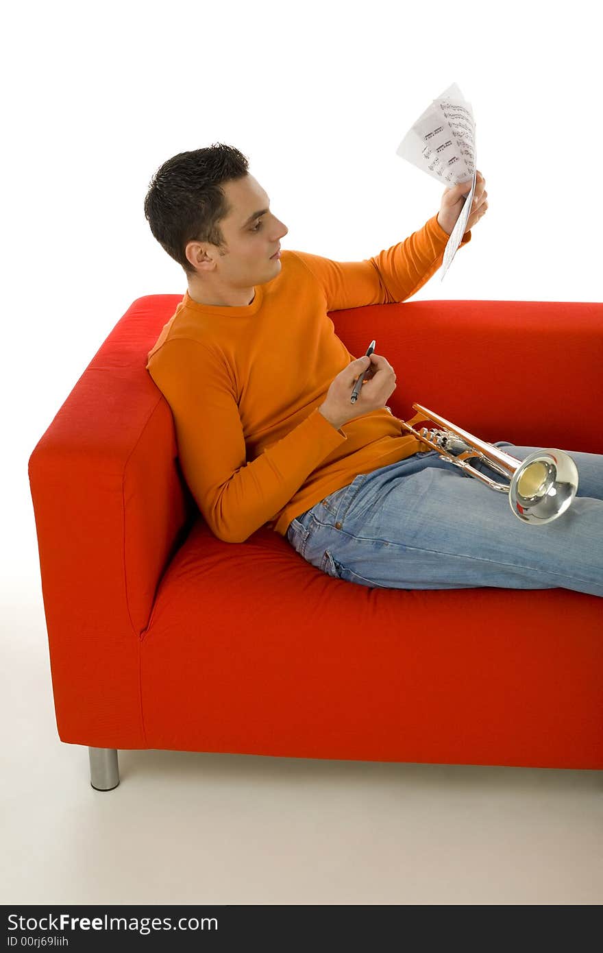 Trumpeter sitting on red couch and composing music, holding sheet music in hands.  White background. Trumpeter sitting on red couch and composing music, holding sheet music in hands.  White background.