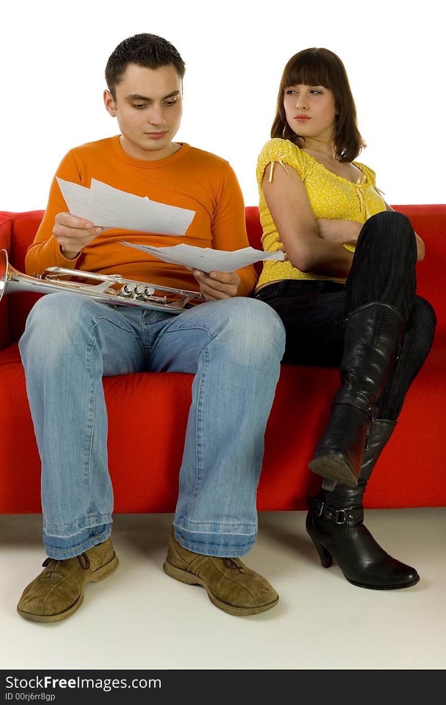 The man and the woman sitting on red couch. Man showing the woman sheet music. She looks insulted. White background. The man and the woman sitting on red couch. Man showing the woman sheet music. She looks insulted. White background.