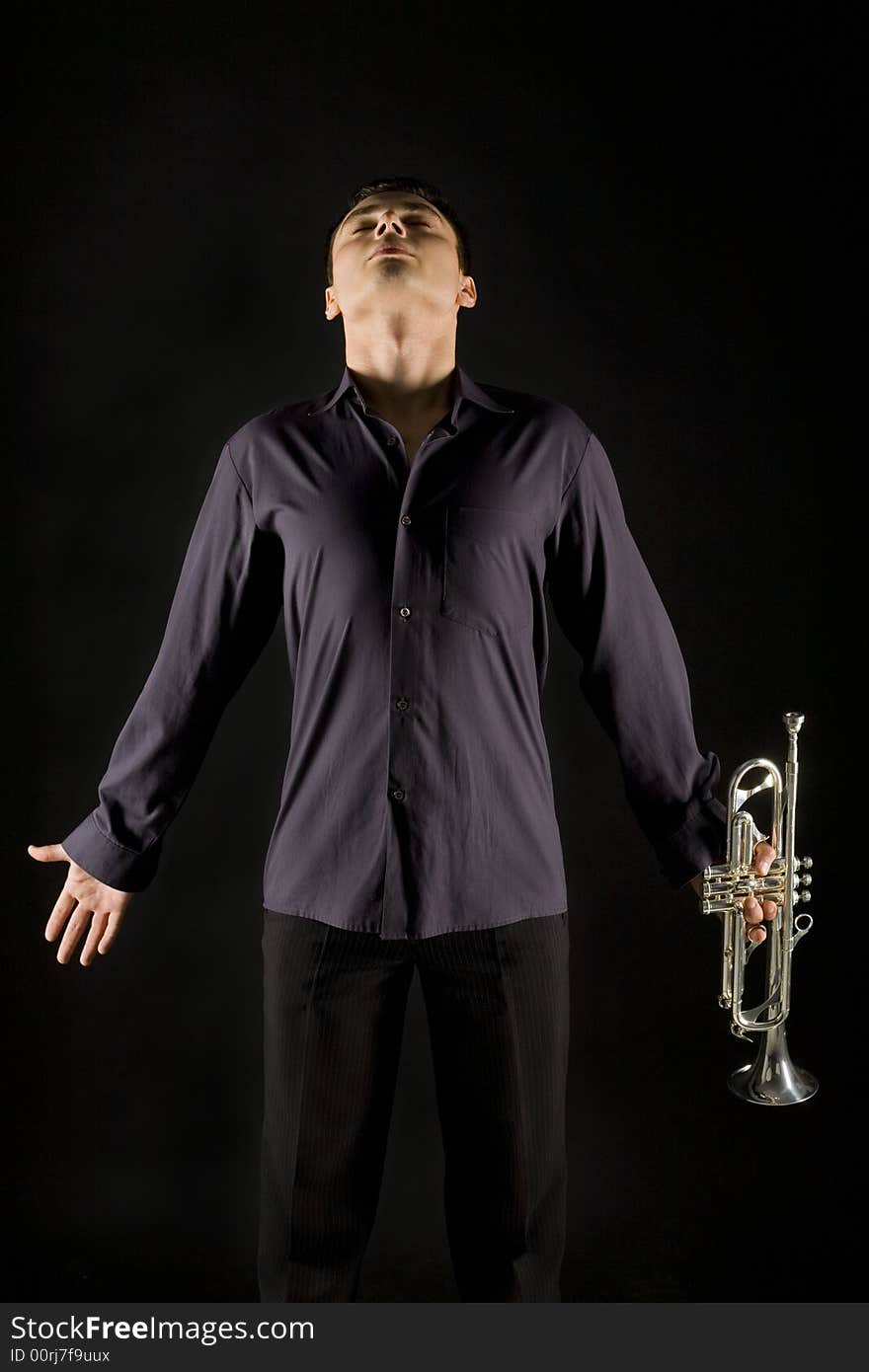 Concentrated man standing with trumpet in hand. Front view. Concentrated man standing with trumpet in hand. Front view.