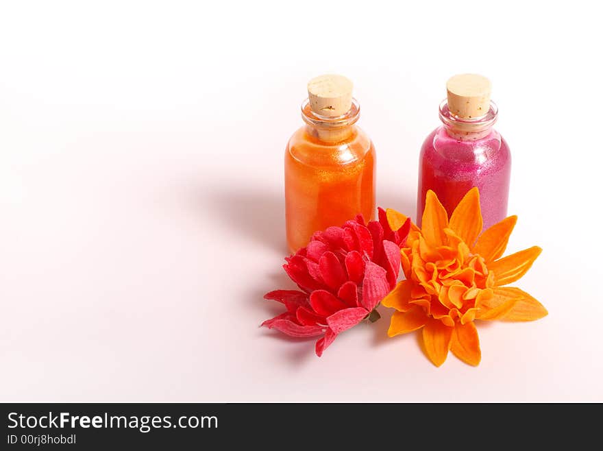 Two bottles, two flowers orange and pink color. Two bottles, two flowers orange and pink color