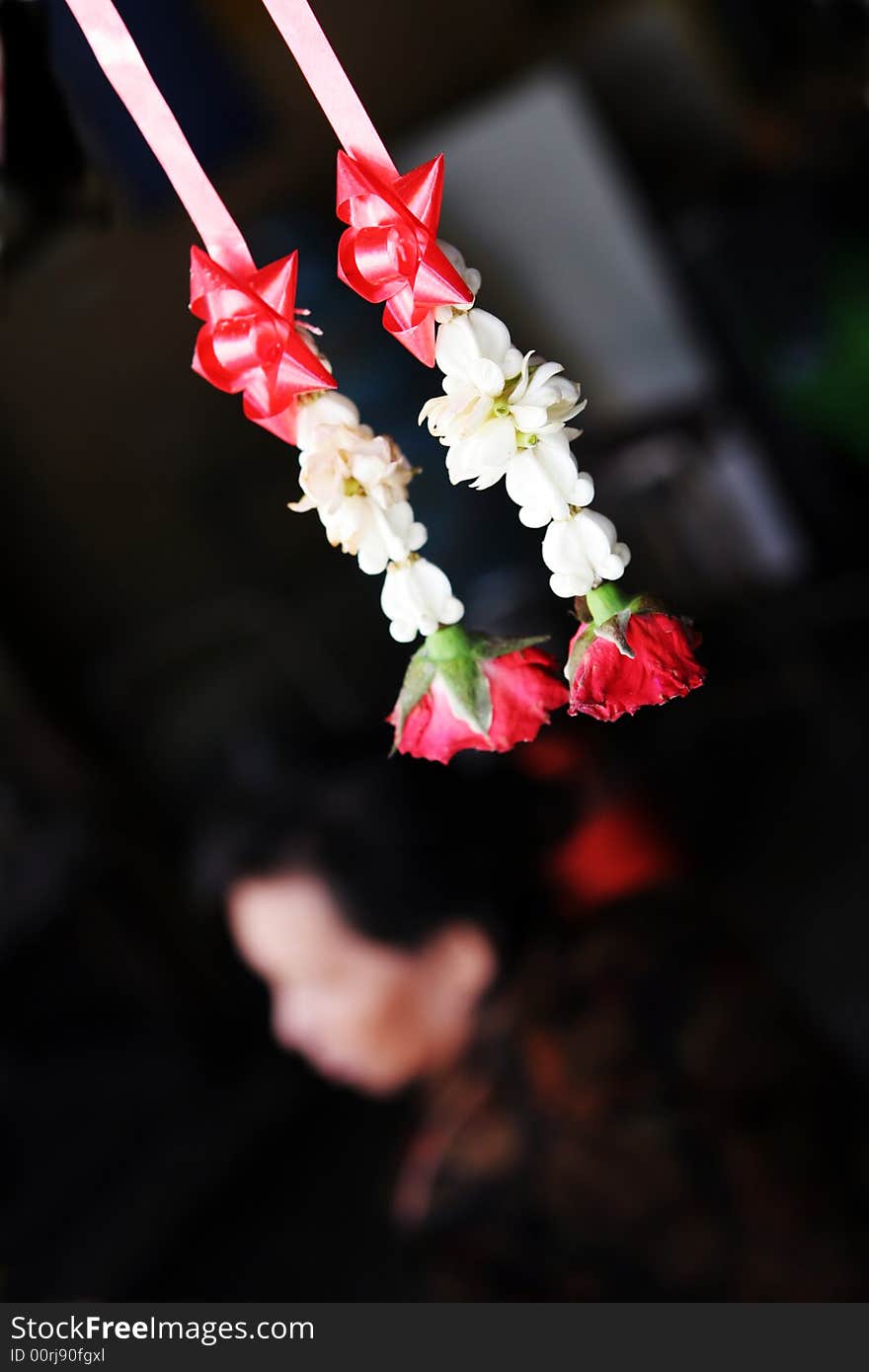 Flowers hanging for good luck in Thailand with an old woman in the background. Flowers hanging for good luck in Thailand with an old woman in the background.