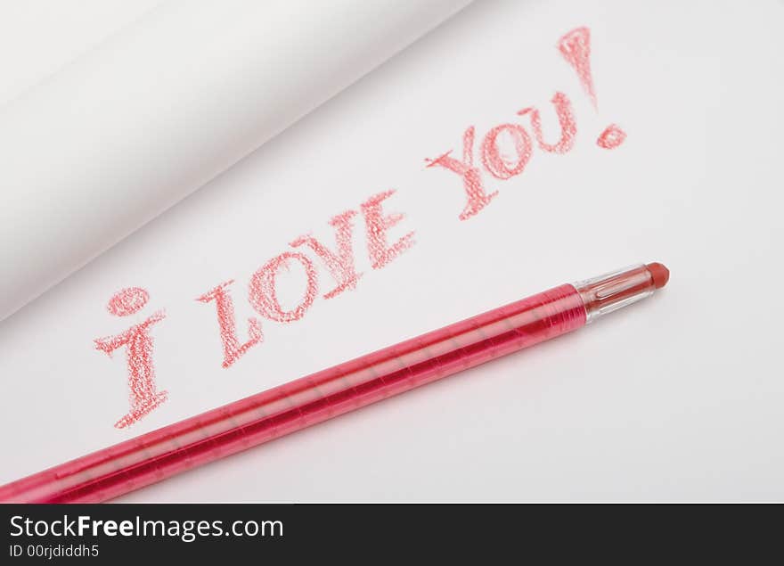 The red pencil lies on a white paper sheet, on sheet is written love message