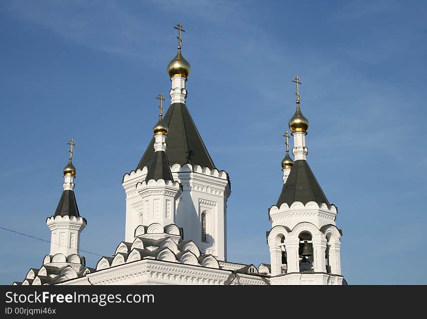 White church with black roof and blue sky. White church with black roof and blue sky