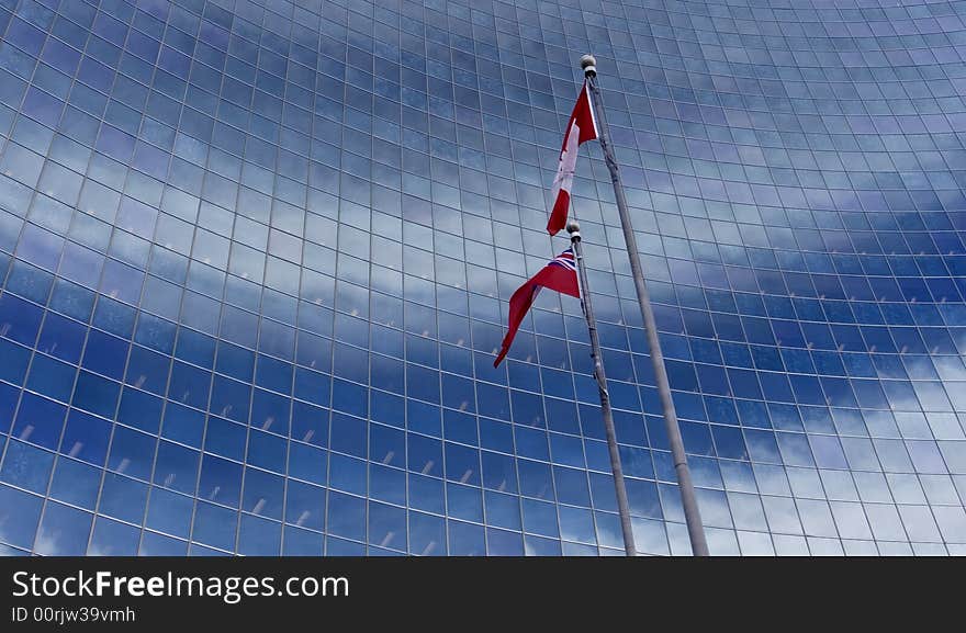 Canadian flag blowing in the wind against windows:. Canadian flag blowing in the wind against windows: