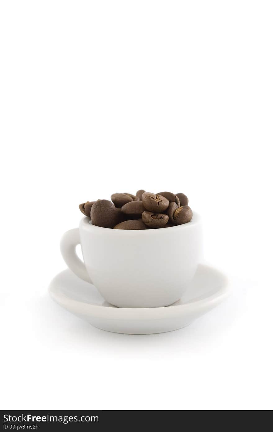 White cup full of coffee beans on white