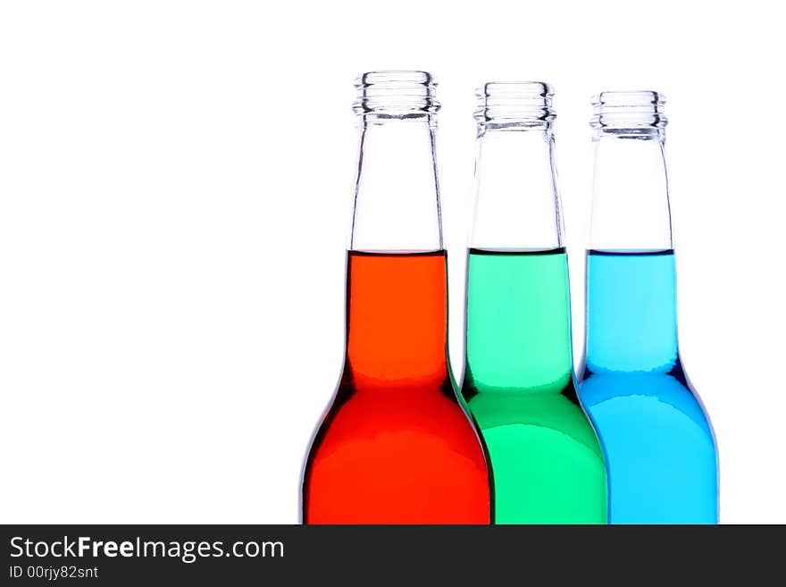 Bottles with red, green, and blue liquid closeup isolated on white. Bottles with red, green, and blue liquid closeup isolated on white