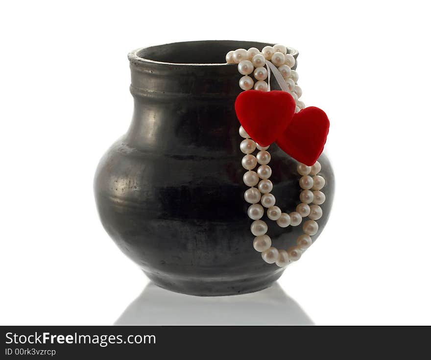 The thread of pearls and hearts hang down from a vase. The thread of pearls and hearts hang down from a vase