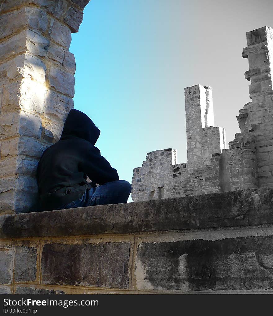 A boy sits on a castle window looking out into the past. A boy sits on a castle window looking out into the past.