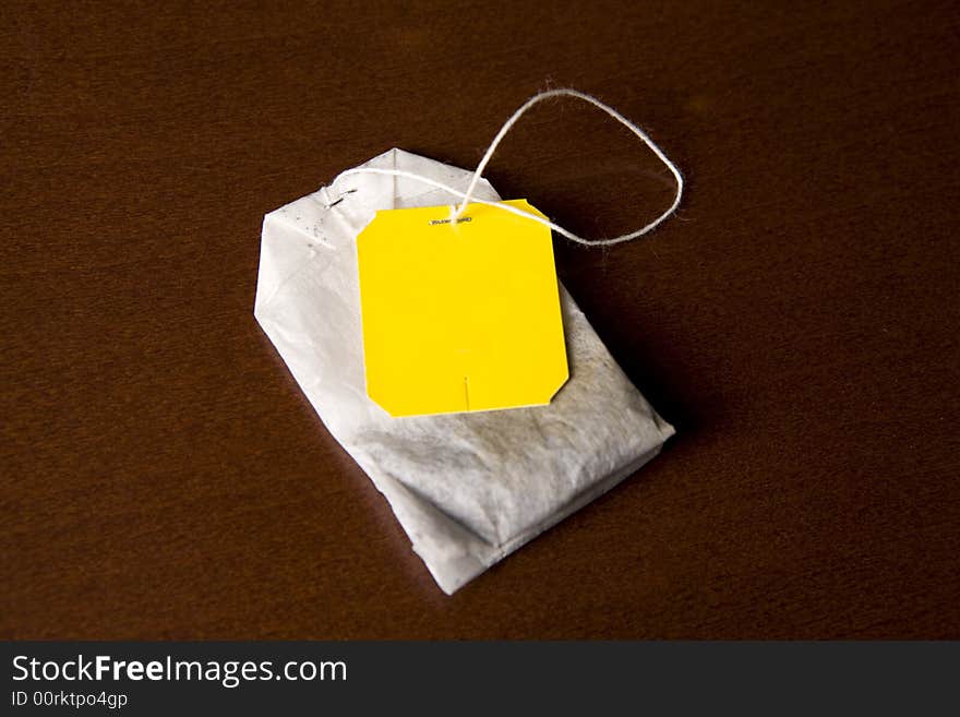 Tea in yellow bags on a brown background. Tea in yellow bags on a brown background