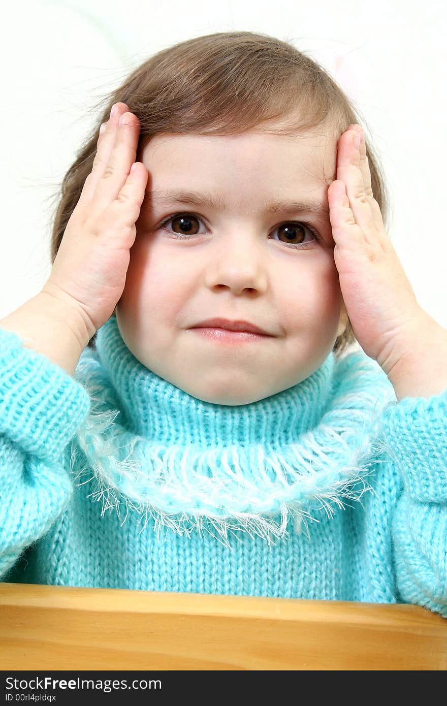 Little girl holds hands head