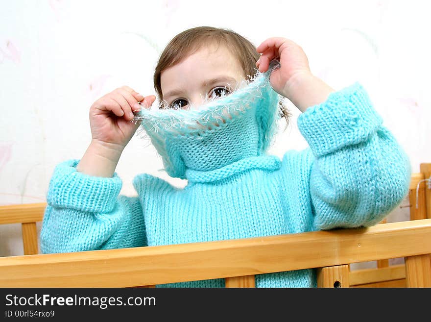 Little girl hides face behind collar of jacket