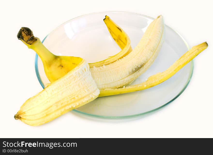 Peeled banana on glass plate on white background