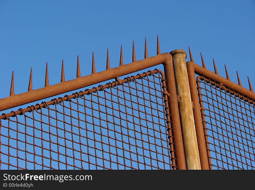 Rusty old fence with a blue sky background