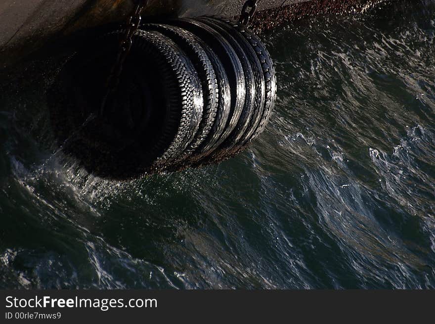 Tires on the pier tide for ship safety. Tires on the pier tide for ship safety